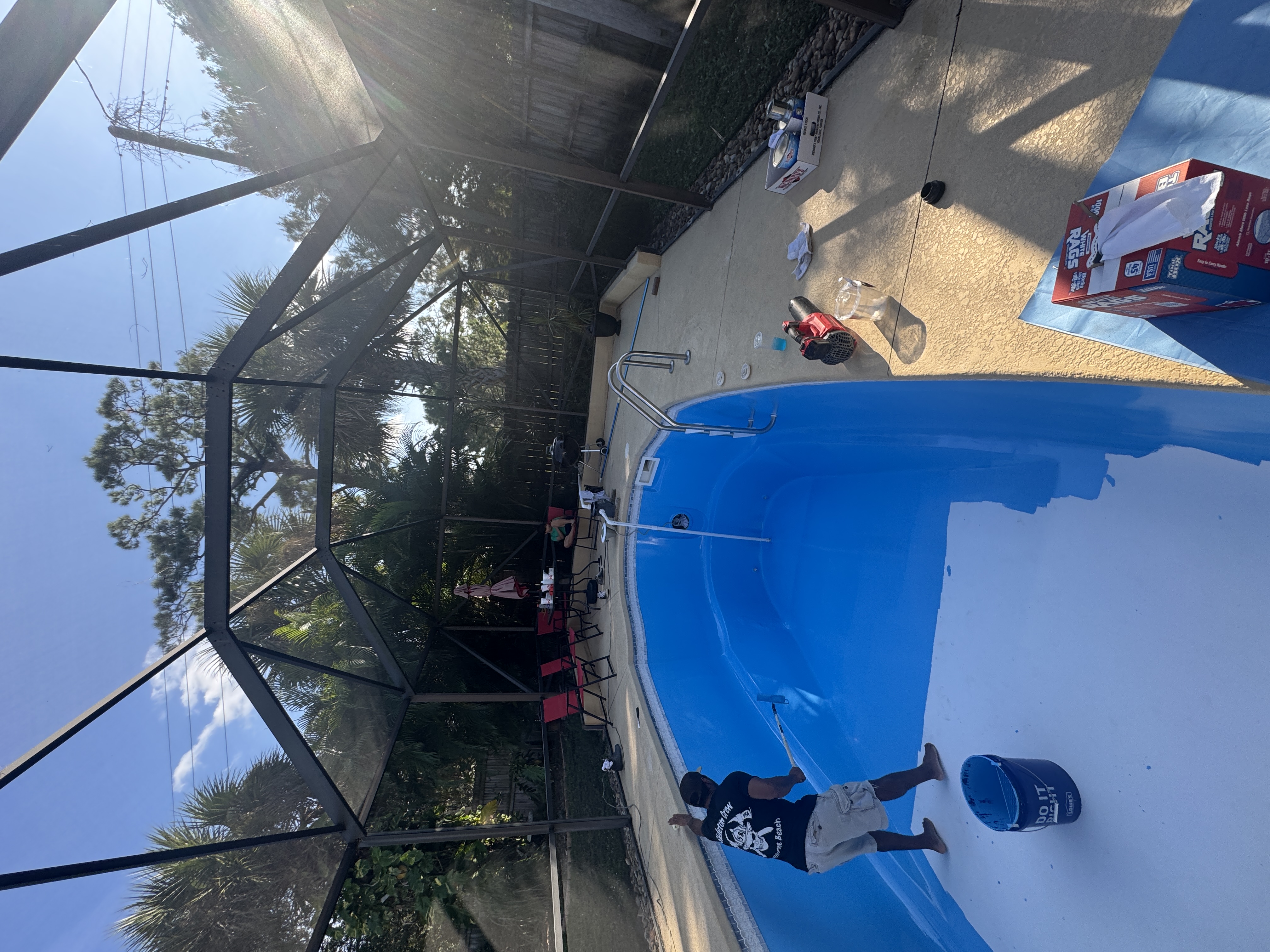 Technician applying fresh pool resurface